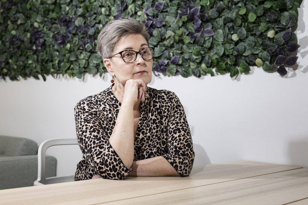 A woman sitting at a table and leaning on her elbow.